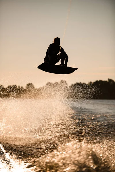 Wakeboarder athlète homme sautant haut faire des tours dans l'air — Photo