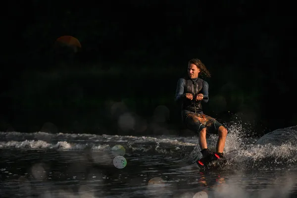 Dalgıç kıyafetli ıslak adam Wakeboard 'da su yüzeyinde enerjik bir şekilde dengede duruyor. — Stok fotoğraf