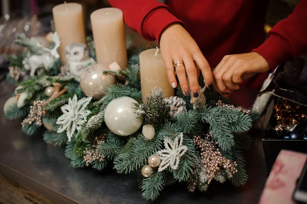 Syn på händer florist kvinna som dekorerar r sammansättning av gran grenar och ljus — Stockfoto