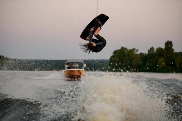 Energi atletisk manlig wakeboarder gör farliga stunts på wakeboard — Stockfoto