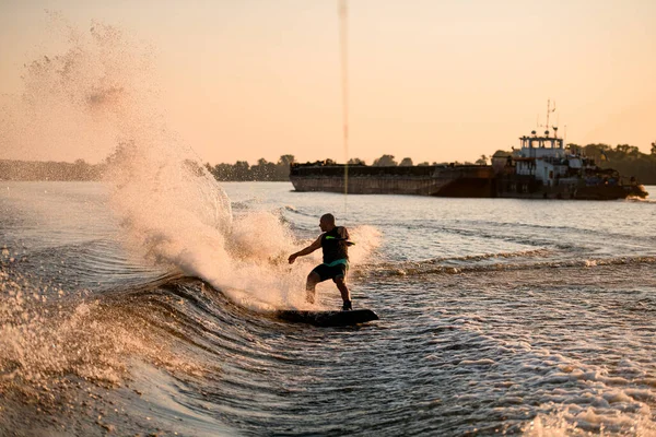 Enerji atletik erkek wakeboardcunun su sürüşü ve arkasında bir sürü sıçrama görüntüsü — Stok fotoğraf