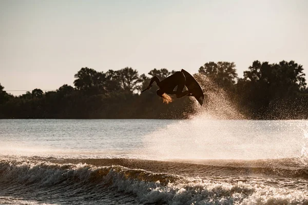 Aktif erkek wakeboardcunun aşırı hareketli hareketlerini, zıplamalarını ve wakeboard 'da taklalar atmalarını görmek harika. — Stok fotoğraf