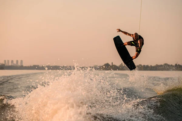 Aktif erkek sürücünün ip tutuşu ve wakeboard üzerinde zıplaması inanılmaz bir manzara.. — Stok fotoğraf