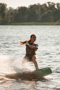 Kadın ipi tutuyor ve nehirde hızla süzülüyor..