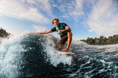 Atletik adam, sıcak bir günde mavi su sıçratan dalgada ustaca süzülerek uyanır.