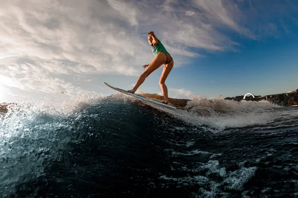 Jovem mulher atraente habilmente equilibra em espirrar onda no wakesurf — Fotografia de Stock
