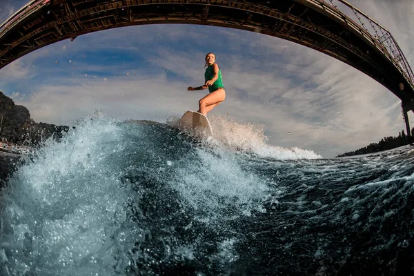 橋の上を飛び回る波の上に女性が乗っているのを見ると. — ストック写真