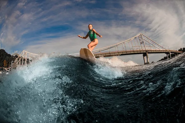 Femme énergique wakesurfer chevauchant la vague éclaboussante bleue par une journée chaude — Photo