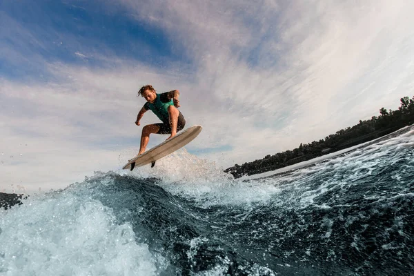 Grande vue de l'homme volant dans les airs sur wakesurf sur la vague éclaboussante — Photo