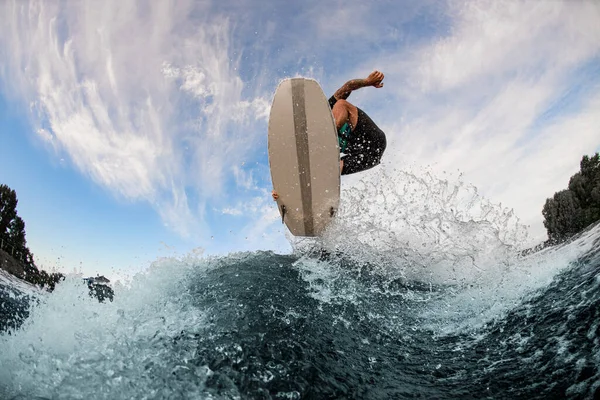 Όμορφη θέα ενός πίνακα wakesurf και ο άνθρωπος άλμα στον αέρα πάνω από ένα κύμα πιτσιλίσματος — Φωτογραφία Αρχείου