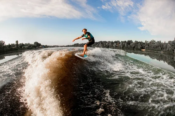Homme athlétique wakesurfer habilement monter le long de la vague éclaboussante bleue sur wakesurf — Photo