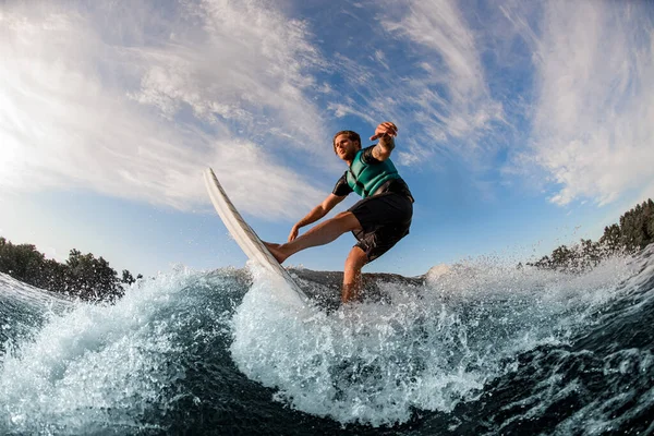 Atlético hombre wakesurfer magistralmente montar por la ola salpicadura azul en un día cálido —  Fotos de Stock