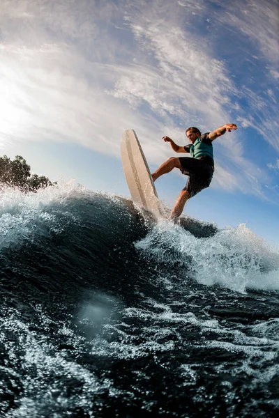 Sportowanie energii wakeboarder wykonuje różne ekstremalne sztuczki na wysokiej fali rozbryzgowej rzeki — Zdjęcie stockowe