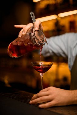 Şarap kadehinin manzarası üzerine parlak kırmızı bir içecek dökülür.