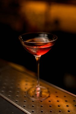 Çelik çubuk yüzeyinde güzel bir kokteyl bardağının yakın açılı görüntüsü