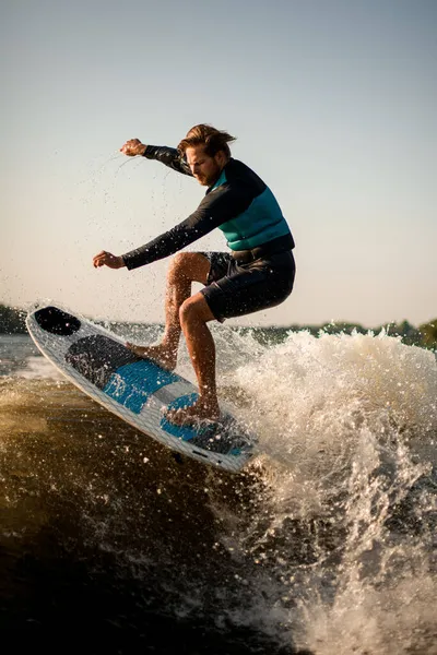 Uomo sportivo fa abilmente saltare con tavola da wakesurf sopra l'onda — Foto Stock