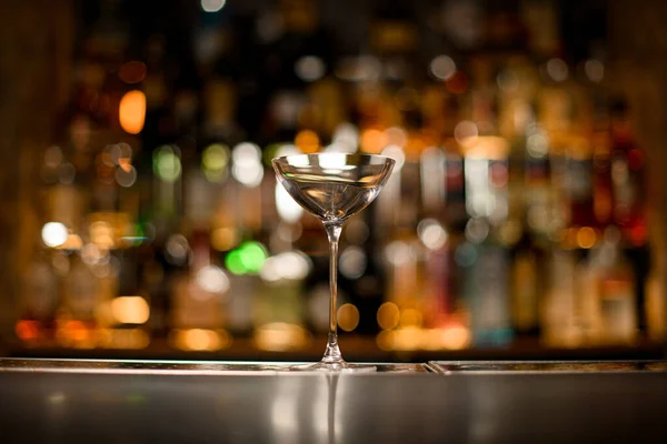 Hermoso vidrio limpio en un mostrador de bar sobre un fondo borroso — Foto de Stock