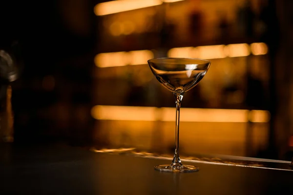 Foco seletivo em belo vidro limpo em um balcão de bar em um fundo turvo — Fotografia de Stock