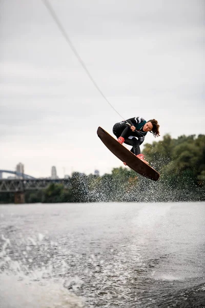 Femelle wakeboarder fait des sauts en hauteur par dessus éclaboussures d'eau — Photo