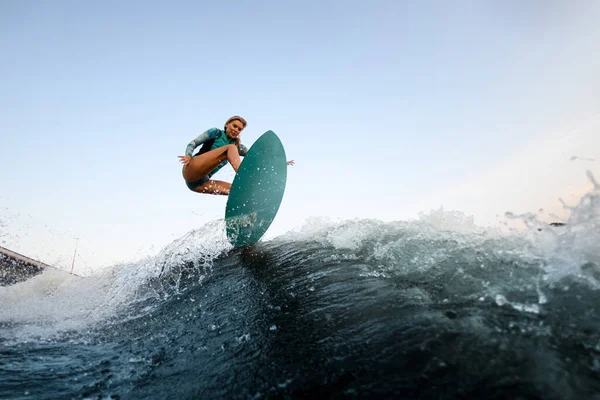Energia mulher wakesurfer pulando no wakesurf para baixo da onda do rio — Fotografia de Stock
