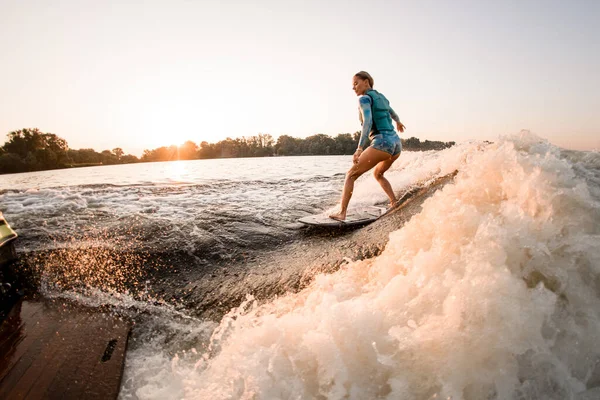 Fitte Frau, die meisterhaft Wakesurf auf plätscherndem Flusswasser reitet. Aktiver Wassersport — Stockfoto