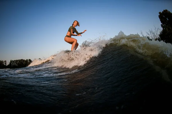 Joven mujer wakesurfer paseo por la ola del río contra el cielo azul. —  Fotos de Stock