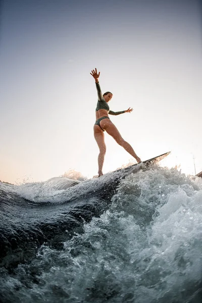 Sexy humide femme wakesurf sur la carte sur la rivière vague contre ciel bleu — Photo
