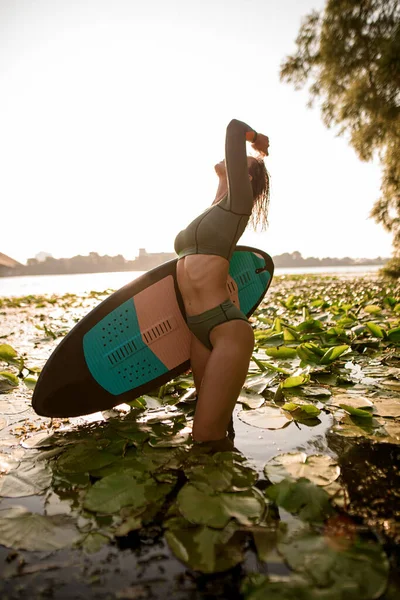 Oldalnézetben szexi nő a vízben egy wakeboard — Stock Fotó