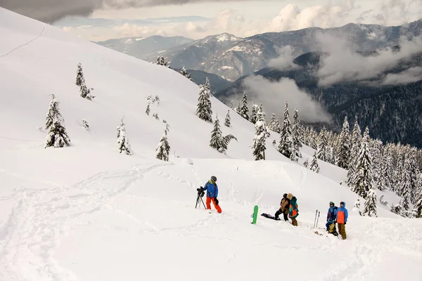 雪に覆われた山々や木々や観光客のグループの眺め — ストック写真