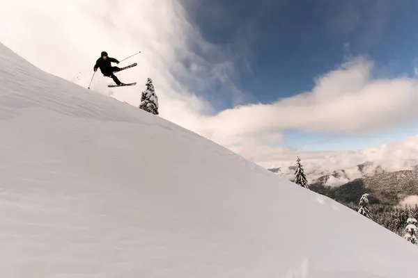Piękny widok na ośnieżone zbocze górskie i narciarz skaczące powietrze — Zdjęcie stockowe