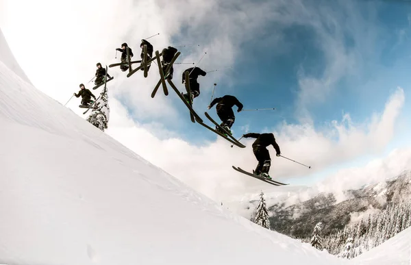 Fantastisk utsikt över snöig bergssluttning och skidåkare hoppa luft — Stockfoto