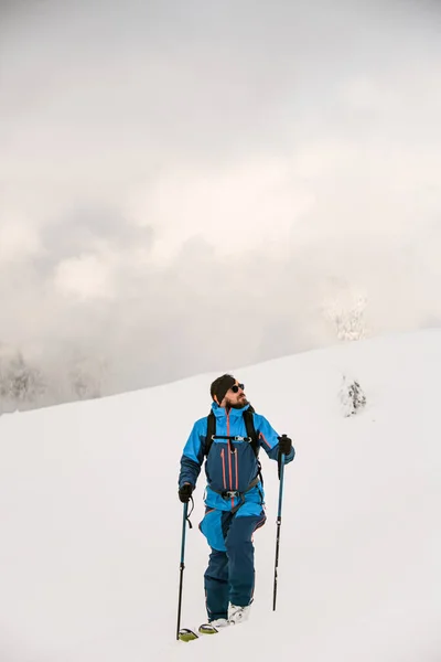 Freeride esquiador andando na neve e olha para longe — Fotografia de Stock