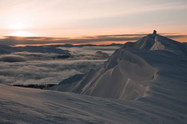 Tozlu kar ve gökyüzü ile kaplı dağ tepelerinin muhteşem kış manzarası
