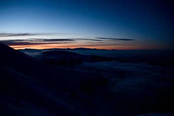 Piękny malowniczy widok wieczorem niebo i wzgórza górskie pokryte śniegiem i jodłami. — Zdjęcie stockowe