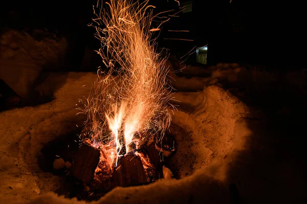 Parlak alev ve kıvılcımlarla uçuşan güzel yanan şenlik ateşi manzarası.