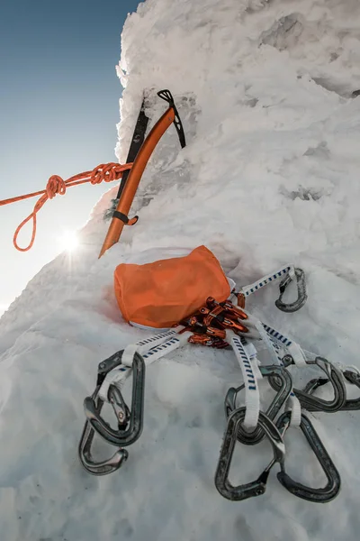 Close-up em equipamentos especiais de escalada monte de carabinas e machado de gelo na neve — Fotografia de Stock
