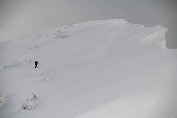 Wspaniały widok na pokryte śniegiem stoku górskiego z narciarzem na nim — Zdjęcie stockowe