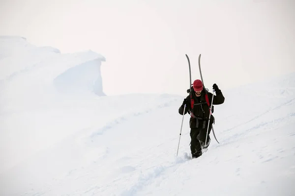 トレッキングポールを持った男が山の斜面の深いパウダースノーを歩き — ストック写真