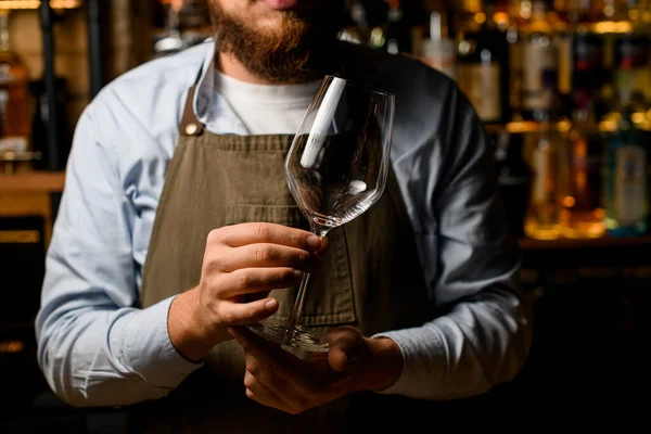 Närbild av manliga bartender händer försiktigt hålla ett tomt vin bägare glas. — Stockfoto