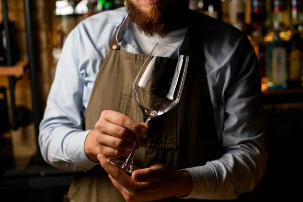 Händerna på en manlig bartender försiktigt hålla tom transparent vin bägare glas. — Stockfoto