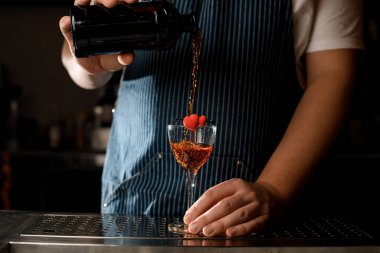 Güzel bir şarap kadehi manzarası. Barmenin şişeden içki içtiği bir kalp ile süslenmiş.