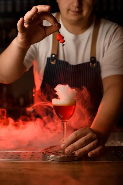 Copa de vino de bebida con espuma blanca y mano de barman decorarlo con pequeño corazón rojo — Foto de Stock