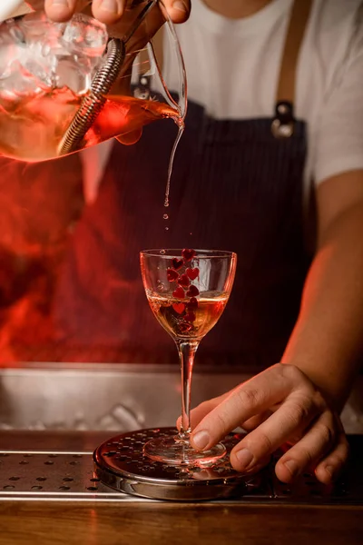 Splendida vista di bicchiere di vino decorato con piccoli cuori rossi e getto di bevanda in esso. — Foto Stock