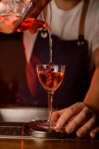 Vista de vinho decorado com pequenos corações vermelhos e derramando jato de bebida para ele. — Fotografia de Stock