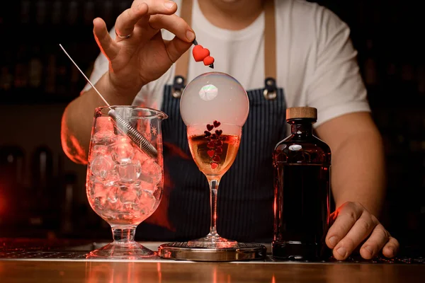 Vista sulla miscelazione tazza, bottiglia e bicchiere di bevanda con bolla d'aria fumosa sulla barra. Corpo del barista sullo sfondo — Foto Stock