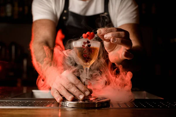 Geweldig uitzicht op wijnglas met drank versierd met kleine rode harten staan op de bar met rook rond — Stockfoto