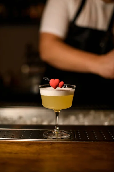 Bel cuore decorativo su vetro con cocktail schiumoso sul bar su sfondo sfocato — Foto Stock