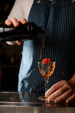 Barmenin içtiği bir kalple dekore edilmiş bir şarap kadehinin yakın plan görüntüsü.