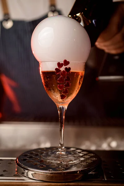 Primo piano di bicchiere da vino con bevanda decorata con cuori e bolla di fumo che fa da blaster sapore — Foto Stock