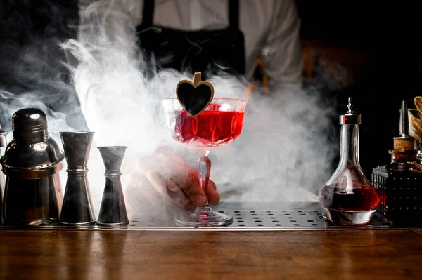 Barista azienda decorato rosso gustoso cocktail alcolico in piccolo bicchiere — Foto Stock